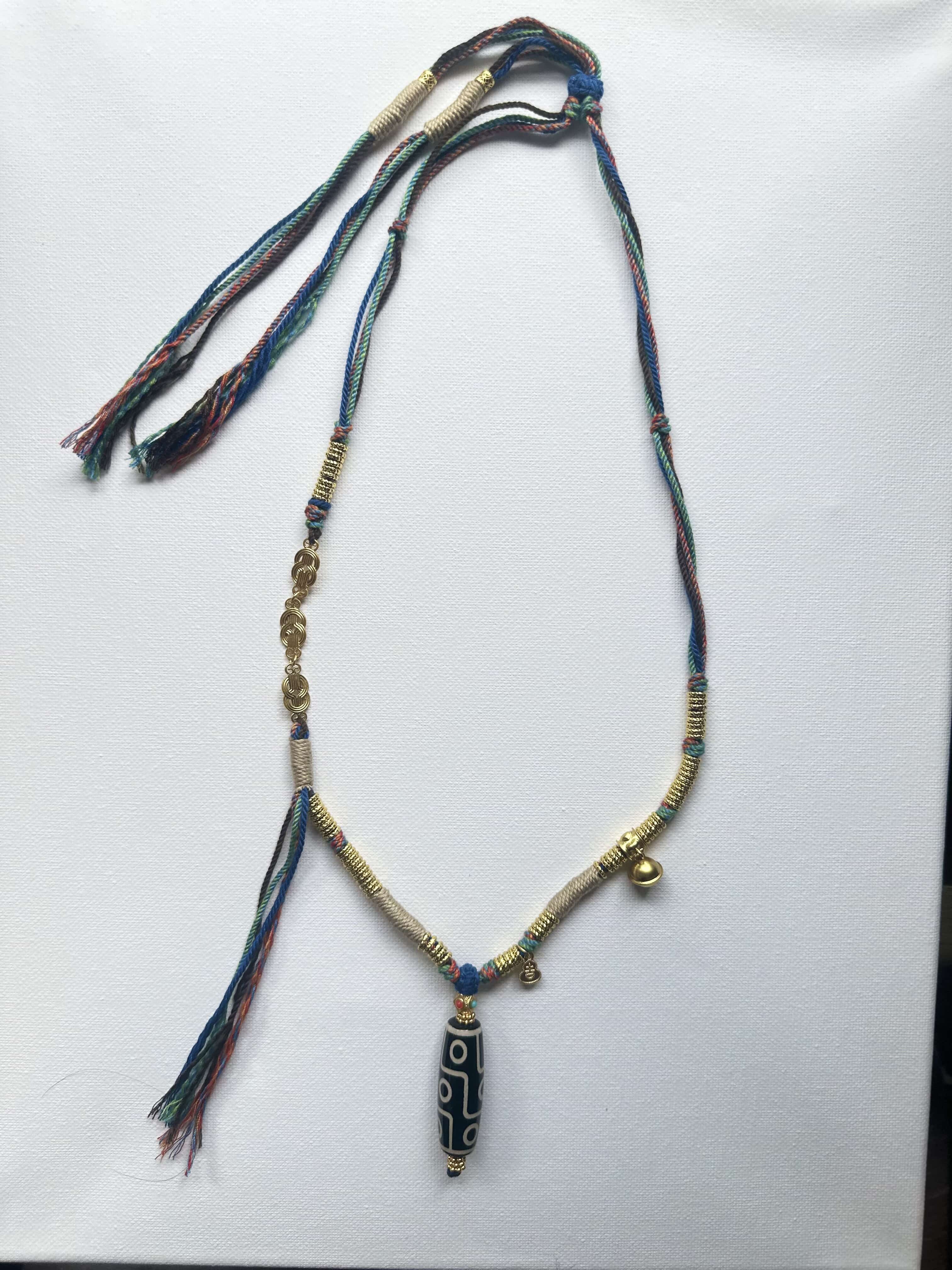 Heavily handwoven necklace with Gold plated metal lucky accessories and Vintage Nine-Eyed DZI bead pendant.