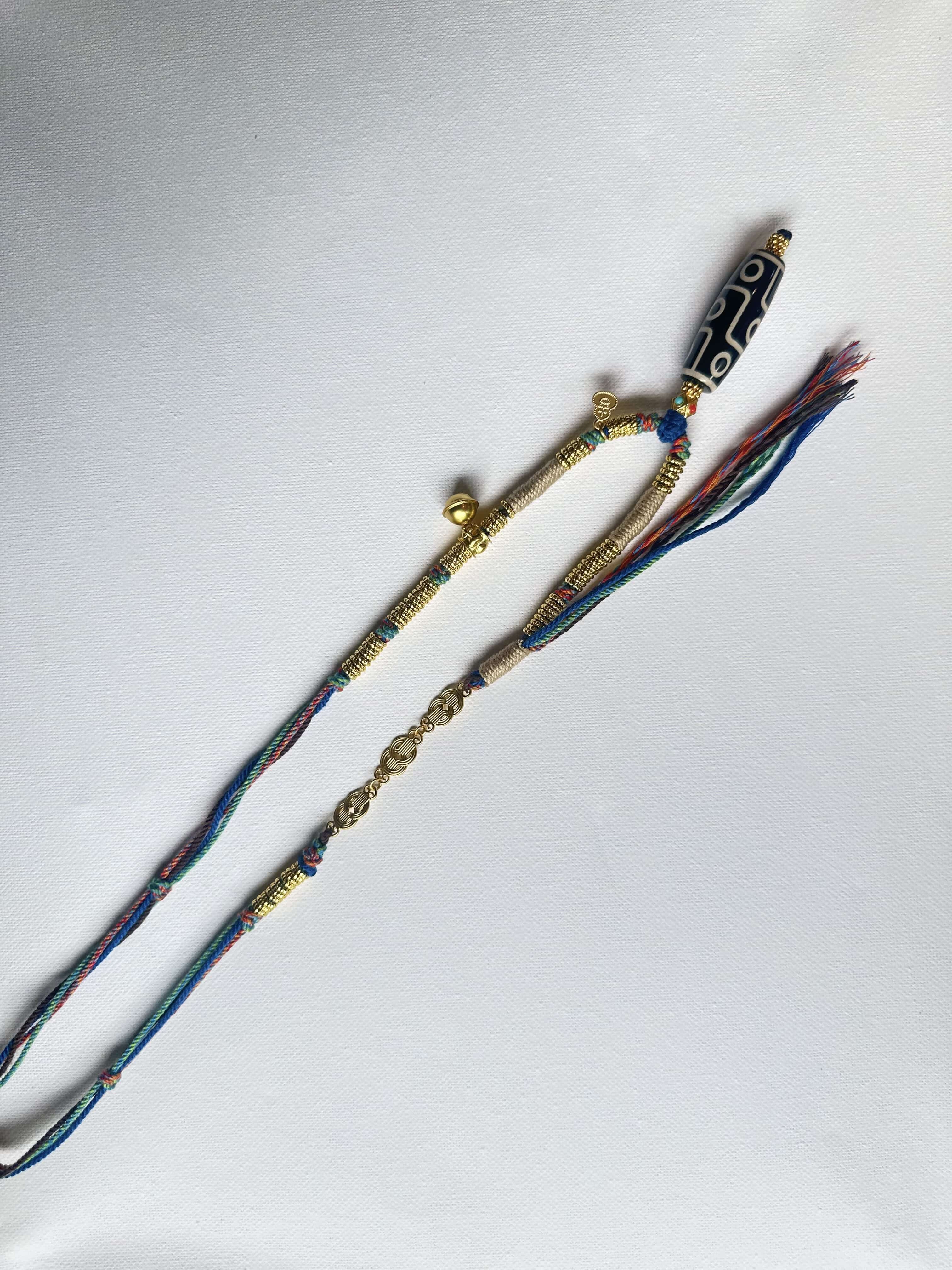 Heavily handwoven necklace with Gold plated metal lucky accessories and Vintage Nine-Eyed DZI bead pendant.