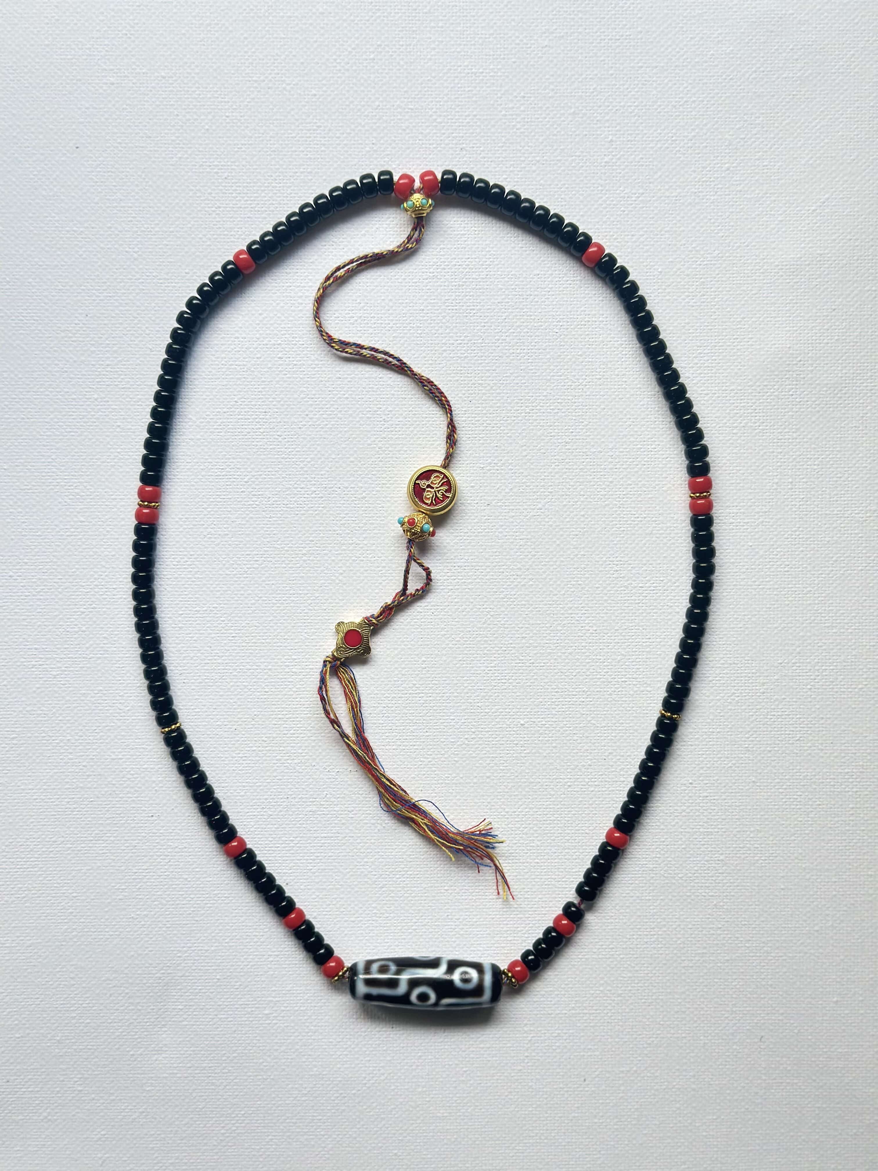 Vintage DZI necklace decorated with black and red glass beads