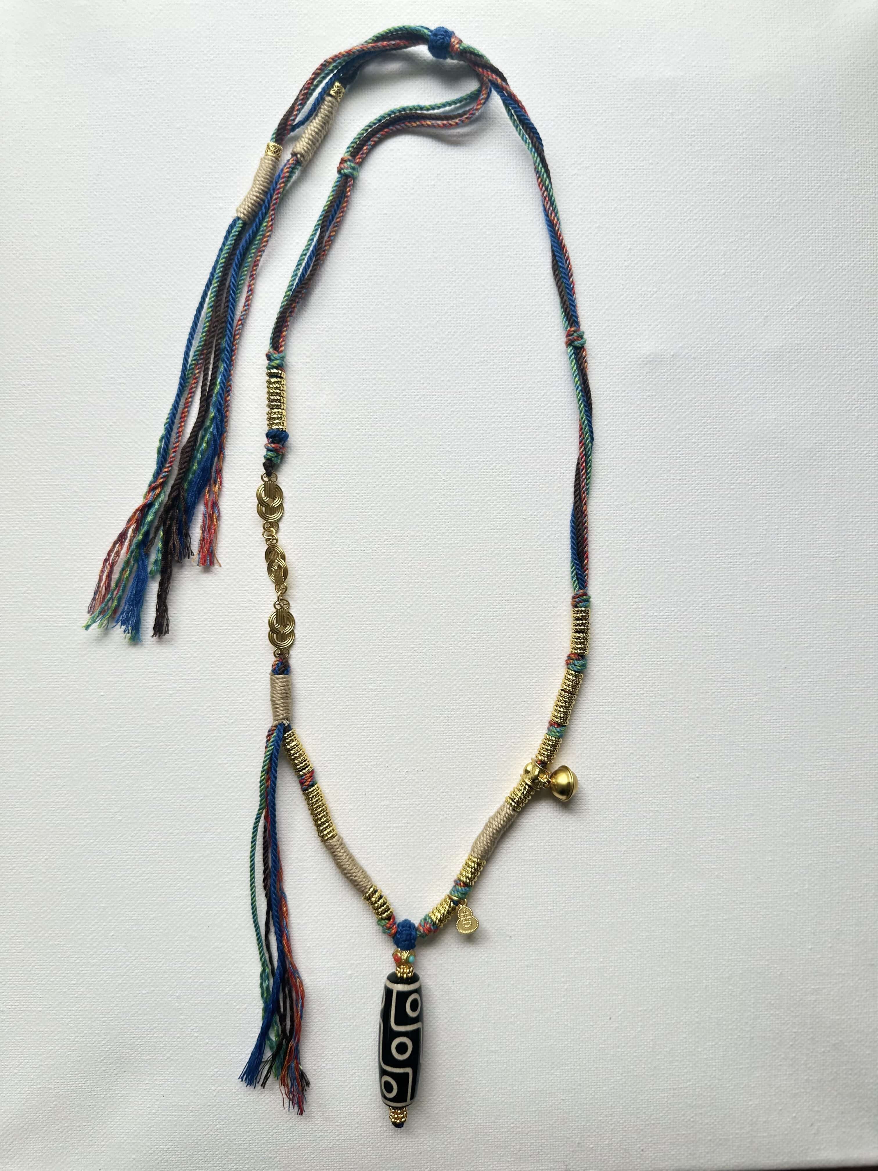 Heavily handwoven necklace with Gold plated metal lucky accessories and Vintage Nine-Eyed DZI bead pendant.