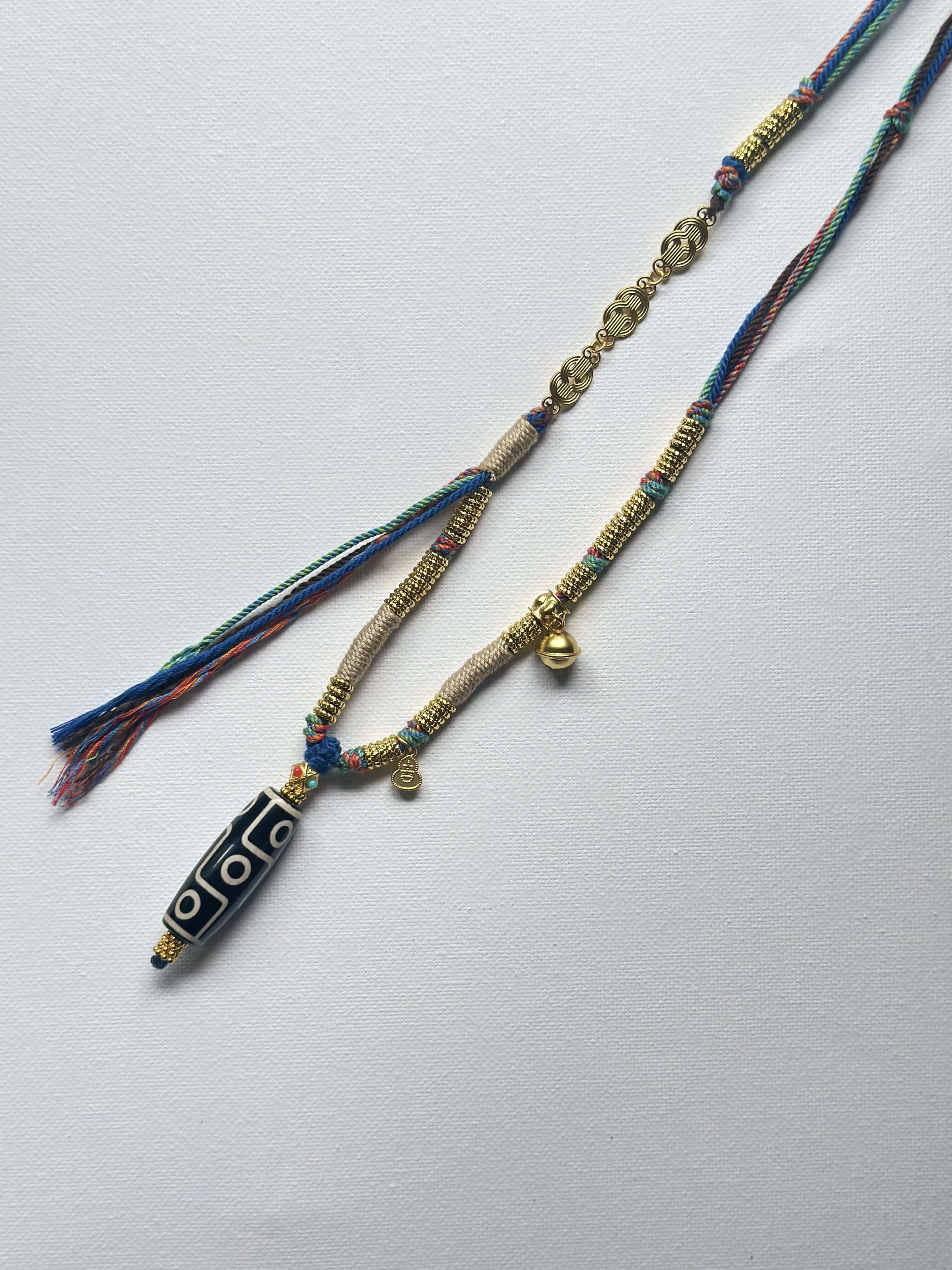 Heavily handwoven necklace with Gold plated metal lucky accessories and Vintage Nine-Eyed DZI bead pendant.
