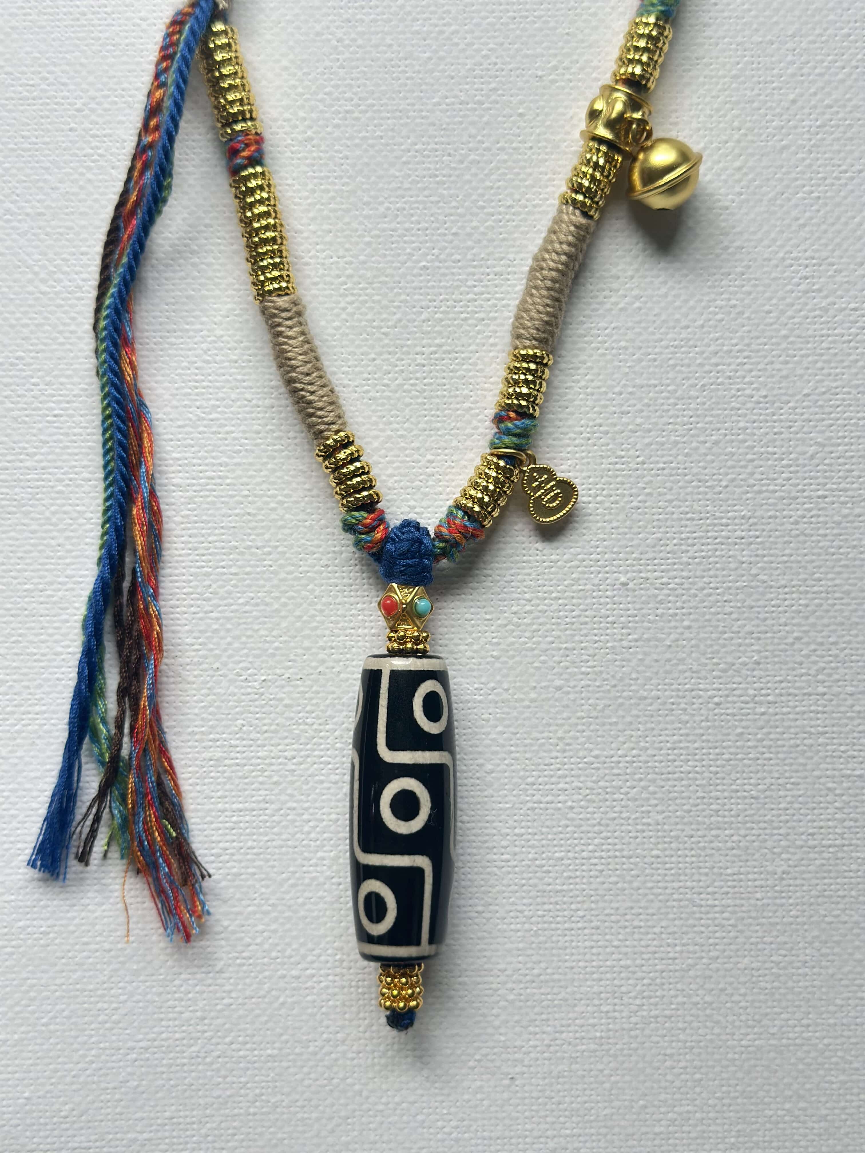 Heavily handwoven necklace with Gold plated metal lucky accessories and Vintage Nine-Eyed DZI bead pendant.