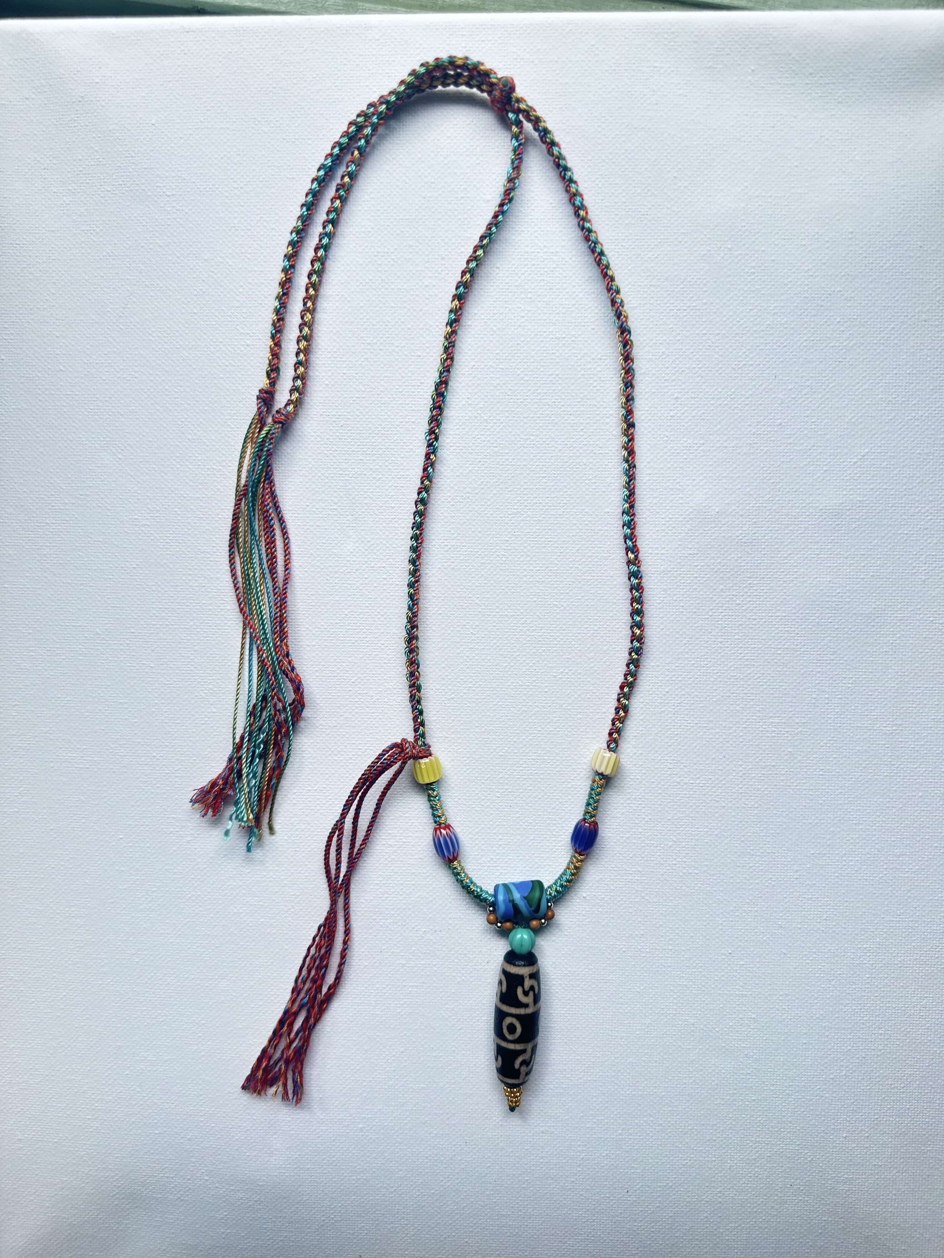 Heavily handwoven with traditional color glass beads and Three-Eyed Dzi of Guru Rinpoche pendant.
