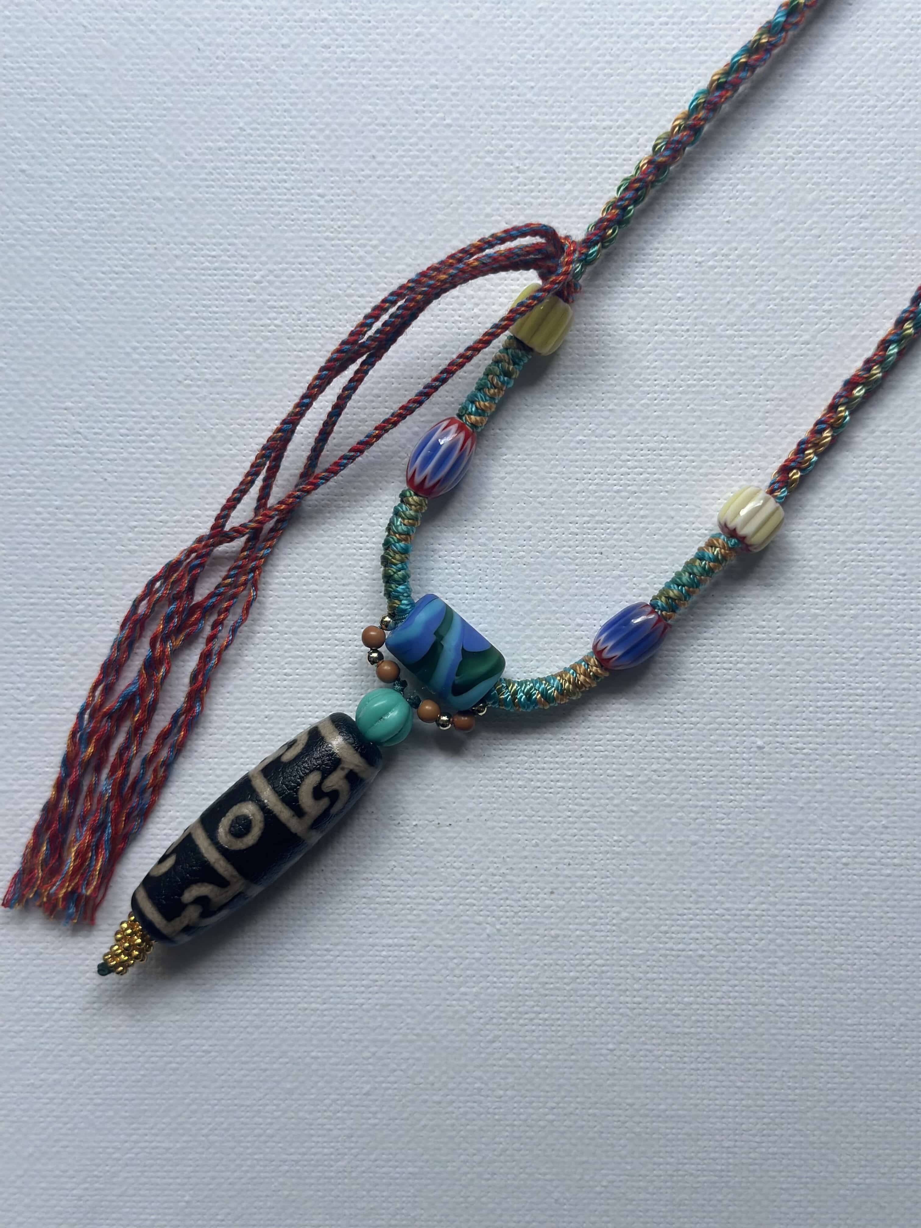 Heavily handwoven with traditional color glass beads and Three-Eyed Dzi of Guru Rinpoche pendant.